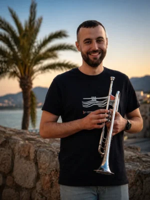 Carles Camarasa sonriendo con su trompeta al atardecer