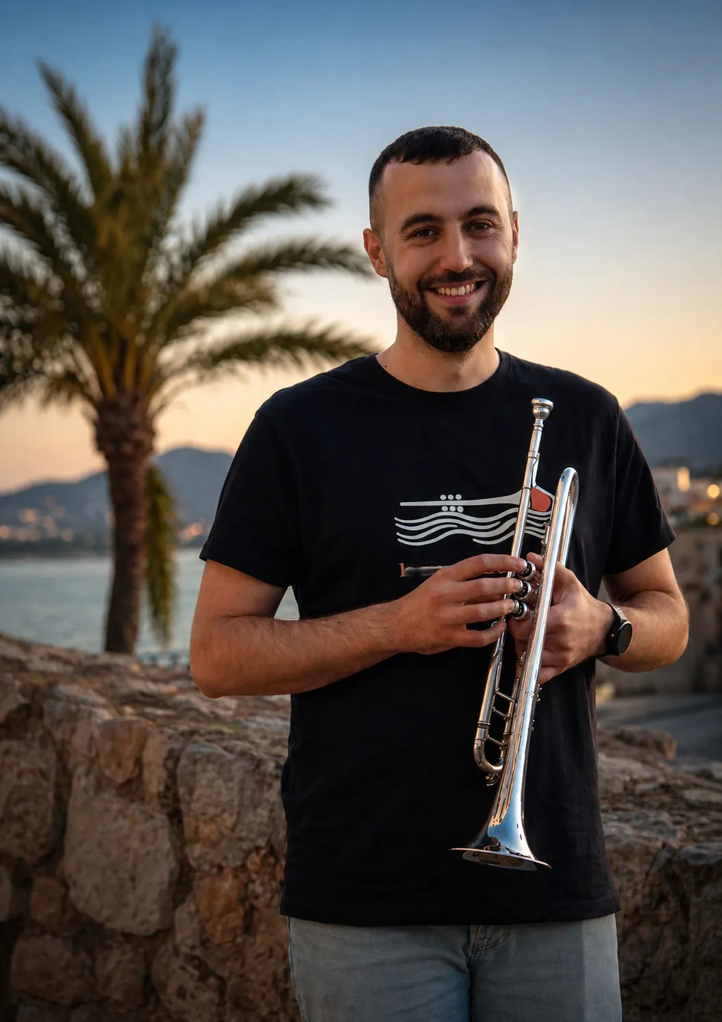 Carles Camarasa sonriendo con su trompeta al atardecer