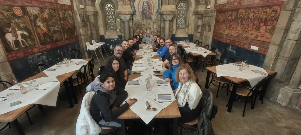 Músicos y acompañantes comiendo juntos en una mesa larga