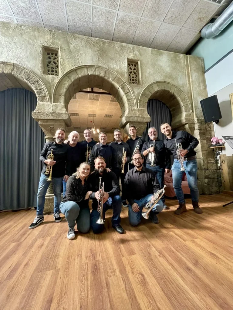 El grupo con sus trompetas en una sala con arcadas pintadas